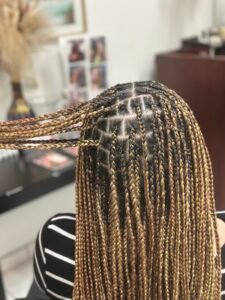 Side view of medium honey blonde knotless braids